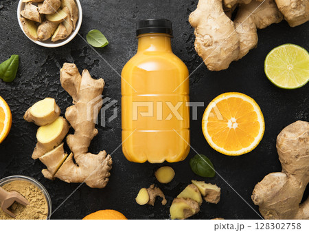 Immune ginger and orange energy shot drink with ginger root and turmeric powder on black. 128302758