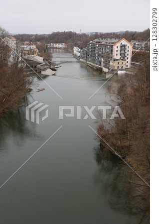 A river runs through a town with a bridge over it 128302799