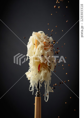 Traditional German sauerkraut with spices on a fork. Traditional German sauerkraut with spices on a fork. 128303318