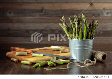 Fresh asparagus in small bucket on a old wooden background. Fresh asparagus in small bucket on a old wooden background. 128303321