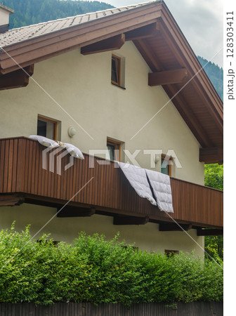 Wooden balcony with white bedding pillows and duvet sun drying . High quality photo Wooden balcony with white bedding pillows and duvet sun drying . High quality photo 128303411