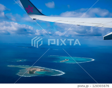 飛行機の窓から見下ろす青い海と島々の絶景　空からの美しい自然風景 128303876