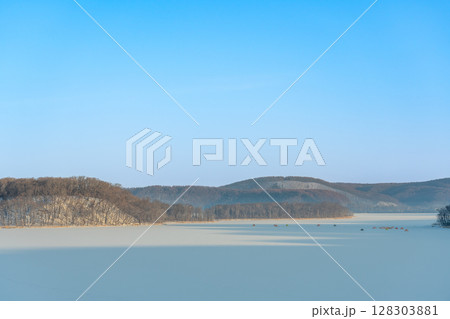 北海道網走市 湖面が凍りついた朝の網走湖とワカサギ釣りのテント 北海道網走市 湖面が凍りついた朝の網走湖とワカサギ釣りのテント 128303881