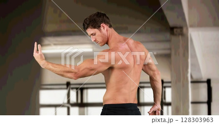 Image of strong muscular man flexing muscles over gym Image of strong muscular man flexing muscles over gym 128303963