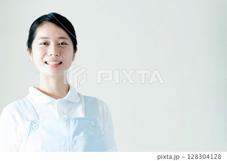 エプロン姿の若い女性 128304128