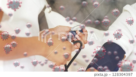 Checking patient's pressure in hospital, doctor with virus cells in background 128304397