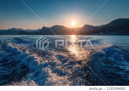 Realistic photo of the sea surface with a blue color and smooth waves, with the sun rising Realistic photo of the sea surface with a blue color and smooth waves, with the sun rising 128304692