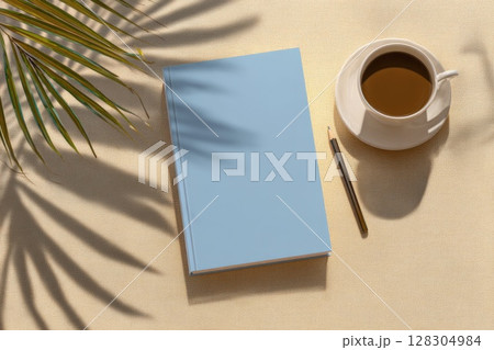 Top view of a flat lay mockup, a blank hardcover notebook on a beige table with a coffee cup 128304984