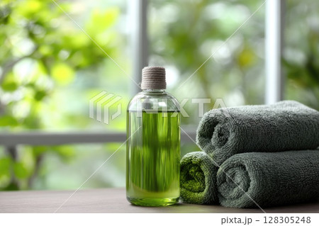 spa concept with natural soap and body lotion bottles on a soft pastel green towel. spa concept with natural soap and body lotion bottles on a soft pastel green towel. 128305248