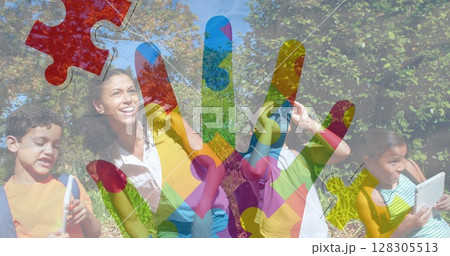 Image of colorful puzzle pieces ribbon over happy playing children Image of colorful puzzle pieces ribbon over happy playing children 128305513