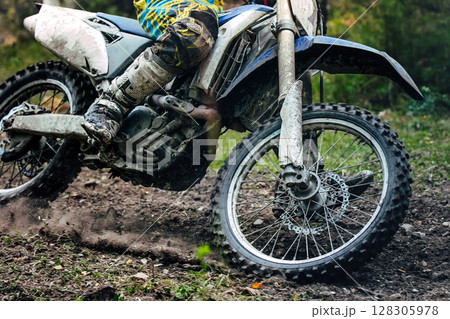 Close-up enduro bike during an off-road race Close-up enduro bike during an off-road race 128305978