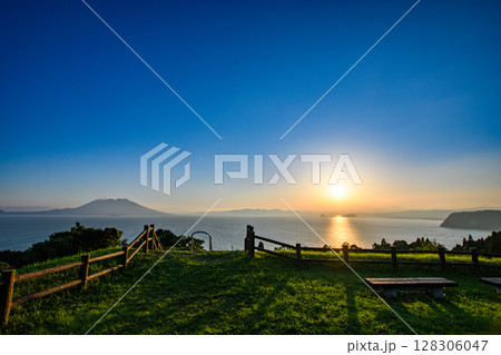 夕暮れ時の海に浮かぶ山 128306047
