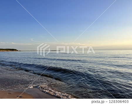 Sunset Rays Over the Sea Breaking Through Clouds 128306403