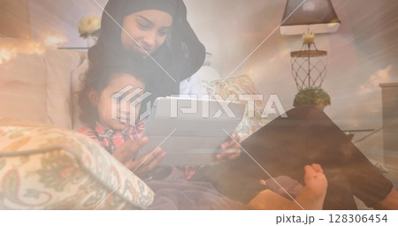 Image of asian mother in hijab with daughter over clouds 128306454