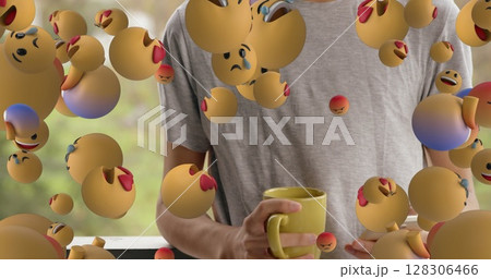 Holding yellow mug, person surrounded by floating emoji faces showing emotions 128306466