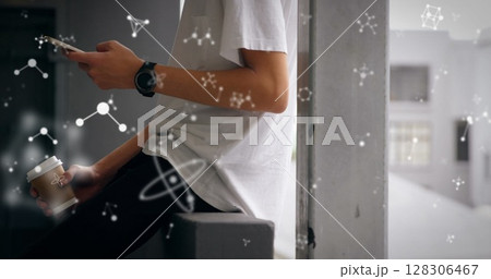 Young man holding coffee and smartphone, surrounded by floating scientific symbols 128306467