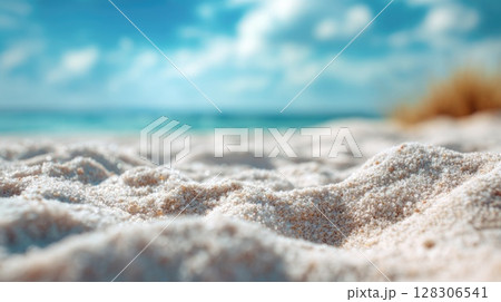 Beautiful summer background with sand and blue sky. Blurred beach scene with copy space 128306541