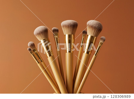 Professional Luxury Golden Bamboo Makeup Brush Set with Synthetic Bristles Against Warm Orange 128306989