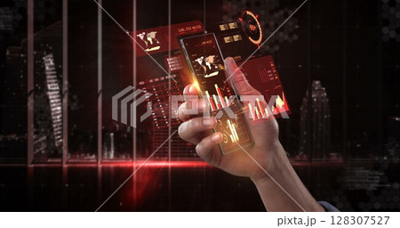 Hand holding smartphone with futuristic digital interface displaying financial data 128307527