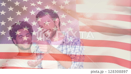 Digital composite of same sex couple smiling and hugging to celebrate new house against animated ame Digital composite of same sex couple smiling and hugging to celebrate new house against animated ame 128308897