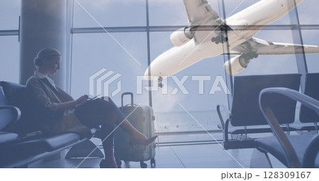 Image of airplane flying over female passenger using digital tablet sitting and waiting in airport l Image of airplane flying over female passenger using digital tablet sitting and waiting in airport l 128309167