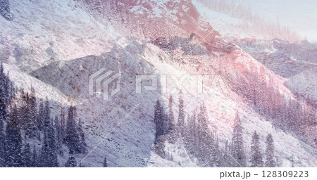 Digital composition of glowing spots of light against snow landscape with mountains and trees 128309223