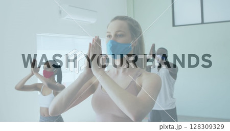 Image of words flashing over diverse group wearing face masks practising yoga 128309329