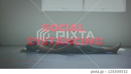 Image of words social distancing over caucsian woman meditating 128309332