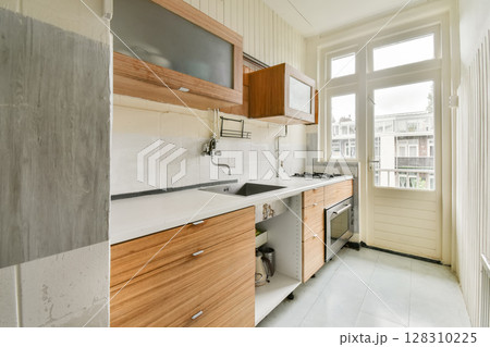 a kitchen with wooden cabinets and white counter tops on the floor in an empty room that has been used for many years 128310225