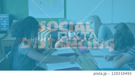 Social distancing text against female teacher teaching disable boy using digital tablet at school 128310493