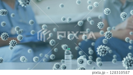 Multiple covid-19 cells floating against covid-19 vaccine bottle on the table at home 128310587