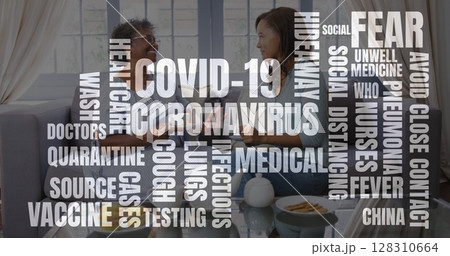 Image of coronavirus text over nurse with senior female patient having tea at home 128310664