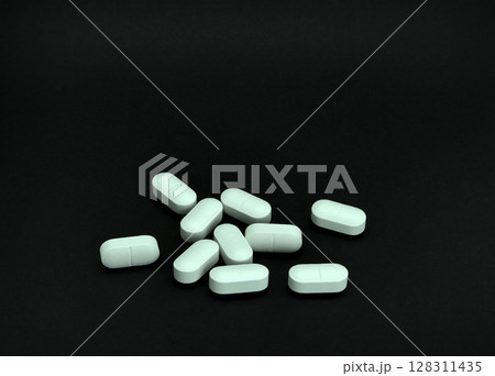 Pile of pills on black background Pile of pills on black background 128311435
