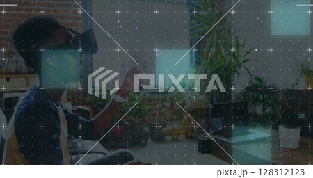 Light trails over grid network against african american man wearing vr headset at office Light trails over grid network against african american man wearing vr headset at office 128312123