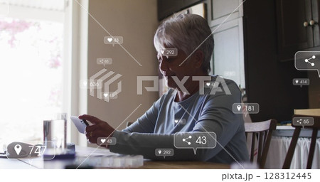 Image of social media icons and numbers on banners over senior woman using smartphone 128312445