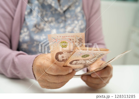 Retired elderly woman counting coins money and worry about monthly expenses and treatment fee payment. Retired elderly woman counting coins money and worry about monthly expenses and treatment fee payment. 128313285