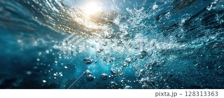 Bubbles rise towards the surface, with sunlight filtering through clear blue water. 128313363