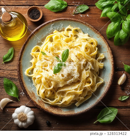 Creamy tagliatelle pasta dish, garnished with fresh basil and cheese. 128313422