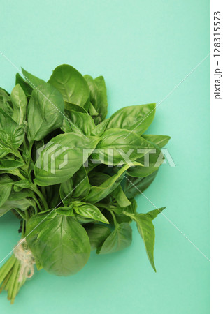 Raw green organic basil leaves on mint background. Raw green organic basil leaves on mint background. 128315573
