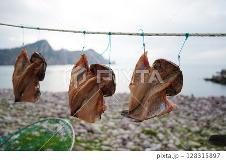 Dried Fish Hanging on Rope by the Sea in Korean Coastal Village 128315897