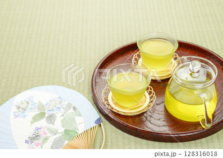 お盆にのせた2客の冷茶と団扇 128316018