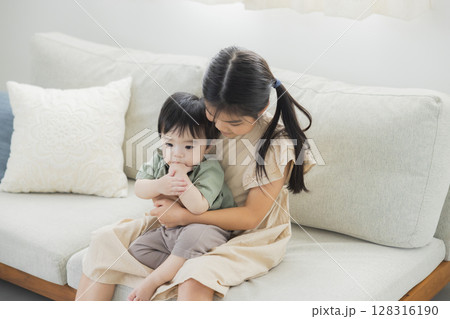 弟を抱っこするお姉ちゃん 128316190