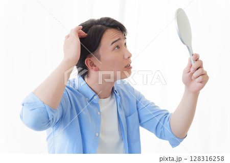 鏡で髪の毛をチェックする男性 128316258