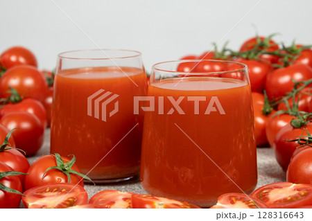 Fresh Tomato Juice in Glasses with Ripe Tomatoes Around. 128316643
