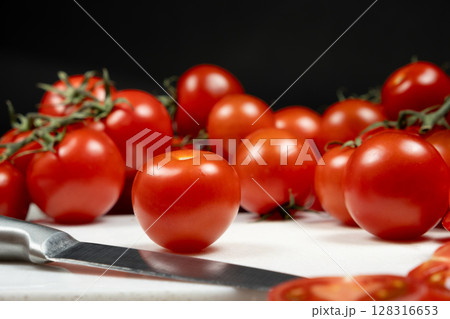 Culinary recipes from fresh tomatoes. Tomatoes on a cutting board with a knife. Culinary recipes from fresh tomatoes. Tomatoes on a cutting board with a knife. 128316653