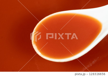 Natural tomato juice from farm tomatoes in a spoon macro Natural tomato juice from farm tomatoes in a spoon macro 128316656