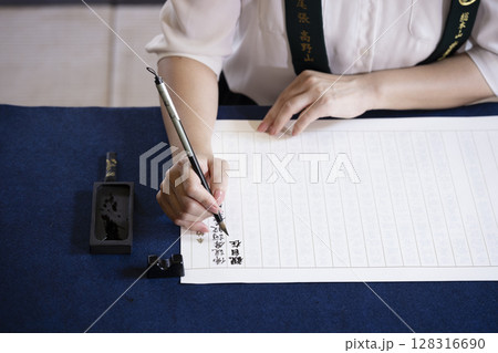 お寺で写経体験をする女性 128316690