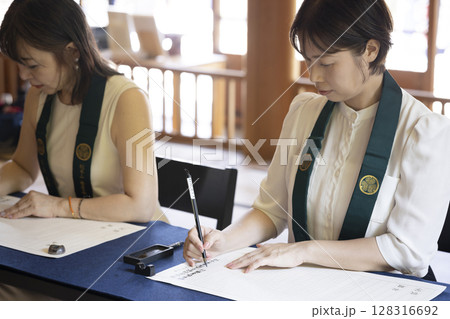 お寺で写経体験をする女性 128316692