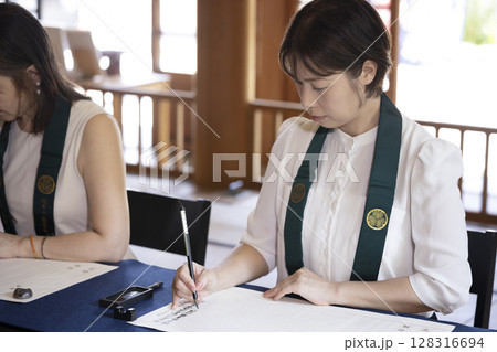 お寺で写経体験をする女性 お寺で写経体験をする女性 128316694