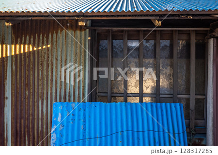 古びたトタンの屋根と壁とガラス戸	 128317285